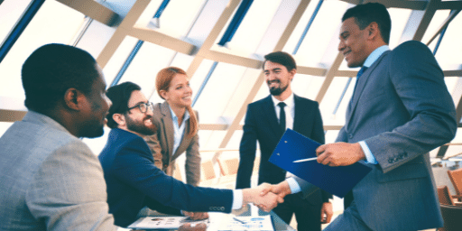 Business people of different genders and ethnicities shaking hands in agreement